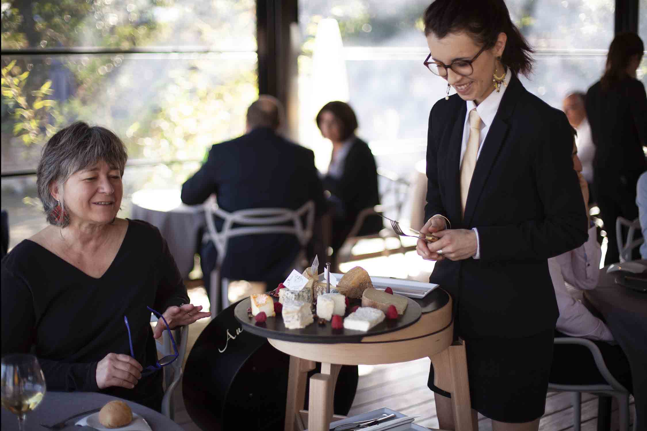 Serveuse réalisant le service à table du fromage sur un chariot à fromages COQ de la marque QUISO au restaurant Le Pois Gourmand à Toulouse, 2017