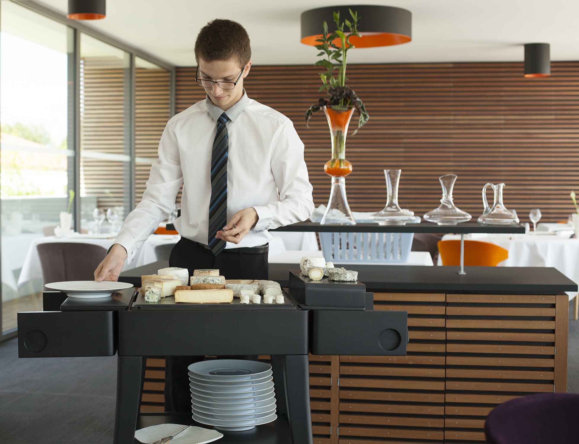 QUISO black beech KEZA cheese trolley used for cheese service by a server in the Lou Look restaurant, 2014